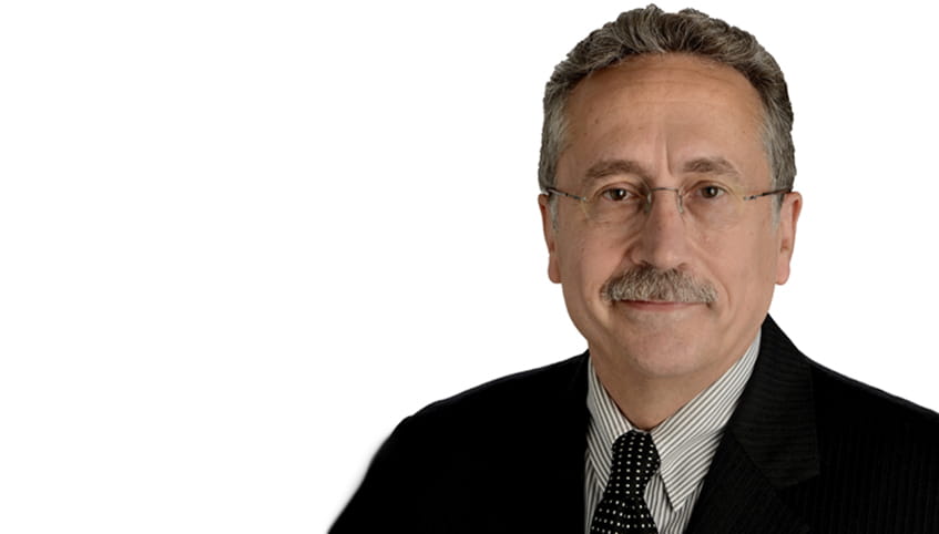 Close up image of a man in a suit with glasses and a mustache