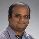 Headshot of an individual in a grey polo shirt